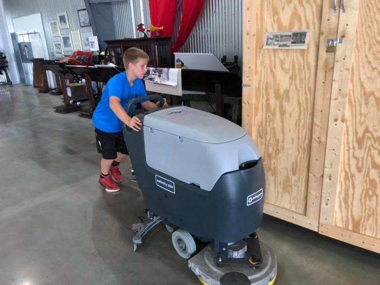 Brody helps clean the hangar floor.